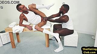 Black and white gay studs engage in intense anal oil fisting