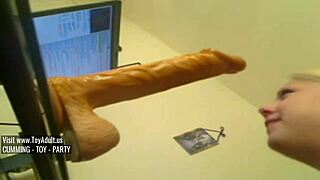 The blonde practices deep throating with a large dildo.