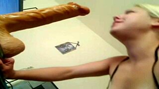 The blonde practices deep throating with a large dildo.