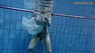 Dark haired teen Andrea floats in pool