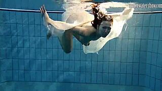 Dark haired teen Andrea floats in pool