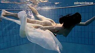 Dark haired teen Andrea floats in pool