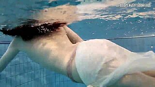 Dark haired teen Andrea floats in pool