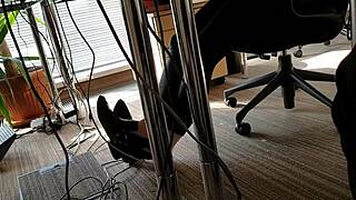 Office worker engages in playful shoe activities during work hours.
