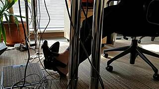 Office worker engages in playful shoe activities during work hours.