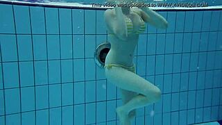Russian redhead babe Lada bathes naked in the pool. Underwater shots reveal her little tits and sexy body.