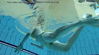 Russian redhead babe Lada bathes naked in the pool. Underwater shots reveal her little tits and sexy body.