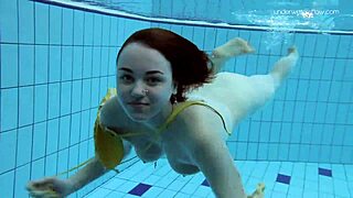 Russian redhead babe Lada bathes naked in the pool. Underwater shots reveal her little tits and sexy body.