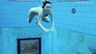 Russian redhead babe Lada bathes naked in the pool. Underwater shots reveal her little tits and sexy body.