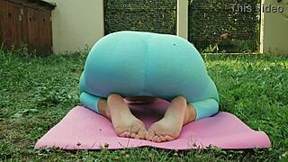 Sexy yoga in blue leggings on a green meadow.