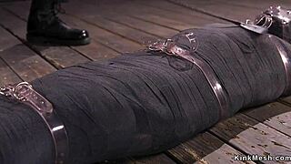 Mummified brunette gets whipped in rough bondage.