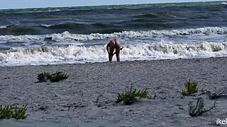 جنس عام على الشاطئ مع كس حليق يُضرب بقضيب هائل