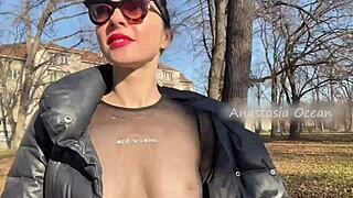 Blonde beauty flashes big boobs walking in public park.