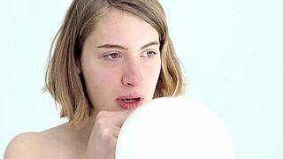 A young babe experiences blowing and popping her first balloon