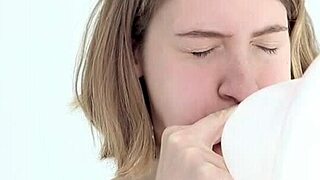 A young babe experiences blowing and popping her first balloon