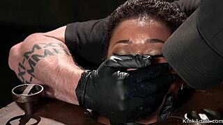 Small-titted ebony sub gets fingered rough while tied in kinky device