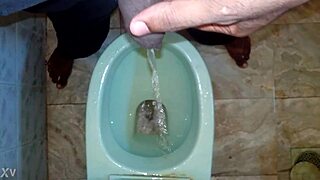 Boy takes a quick pee while the black man handles his own pissing moment outdoors.