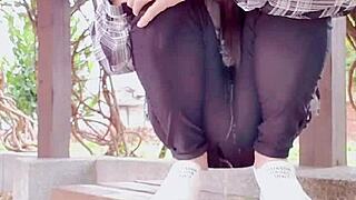 Chinese crossdressing ladyboy masturbates outdoors in stockings during midday urge.