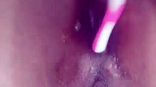ebony performer inserts a brush into her anus for pleasure