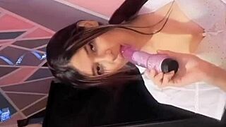 Universitaria se toca con su dildo in bed while flashing big tits and lingerie in dirty talk fetish scene.