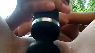 Horny Latina girl stimulates shaved virgin pussy with vibrator outdoors.