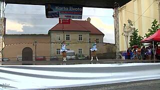 two nice majorettes practice routines together in the sunny park field