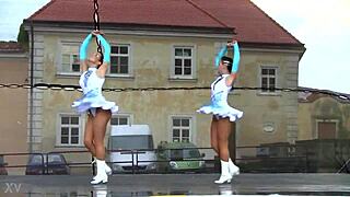 two nice majorettes practice routines together in the sunny park field