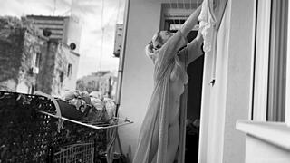 Naked chubby woman with big tits hangs laundry on balcony for neighbors to watch