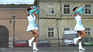 two nice majorettes practice routines together in the sunny park field