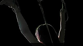 Captured in the dark for BDSM play that contrasts light and shadow with intriguing bondage twists