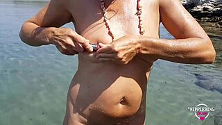 Nippleringlover enjoys hot pissing on a nude beach with pierced pussy wide open and huge pierced nipples