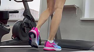 Muscular gym brunette spreads wet pussy during intense leg workout