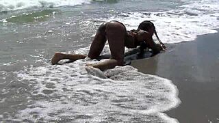 ebony babe pounds dripping pussy with dildo on public beach 🌊