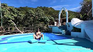 tattooed latina plays around by the pool outdoors