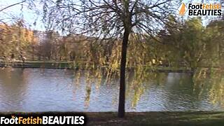 brunette babe slips off socks in park showing bare feet toes and candid outdoor tease