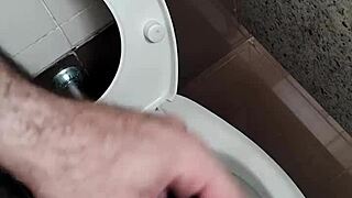 Guy masturbates with handjob in public bathroom toilet