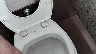 Guy masturbates with handjob in public bathroom toilet